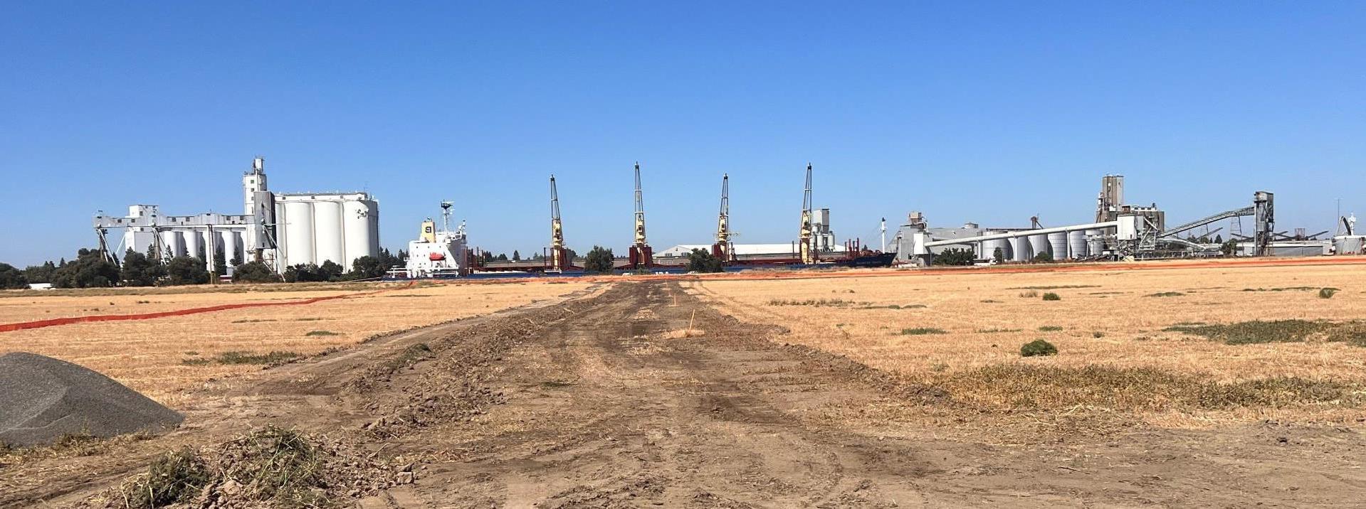 Construction breaking ground with Port of West Sacramento in background.